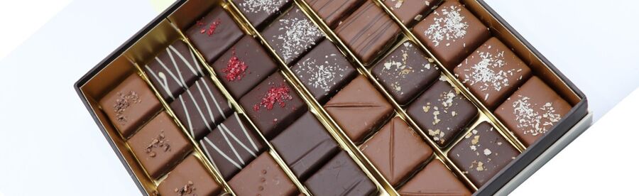 Coffret de bonbons assortis, ouvert sur fond clair
